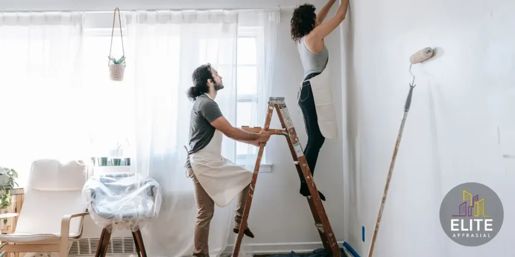 Couple painting interior walls white during pre-appraisal home improvements to increase property value and appraised worth