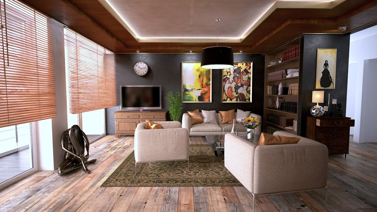 A college student sitting comfortably on a couch with a laptop in a bright, modern living room, showcasing the ideal home environment for studying.
