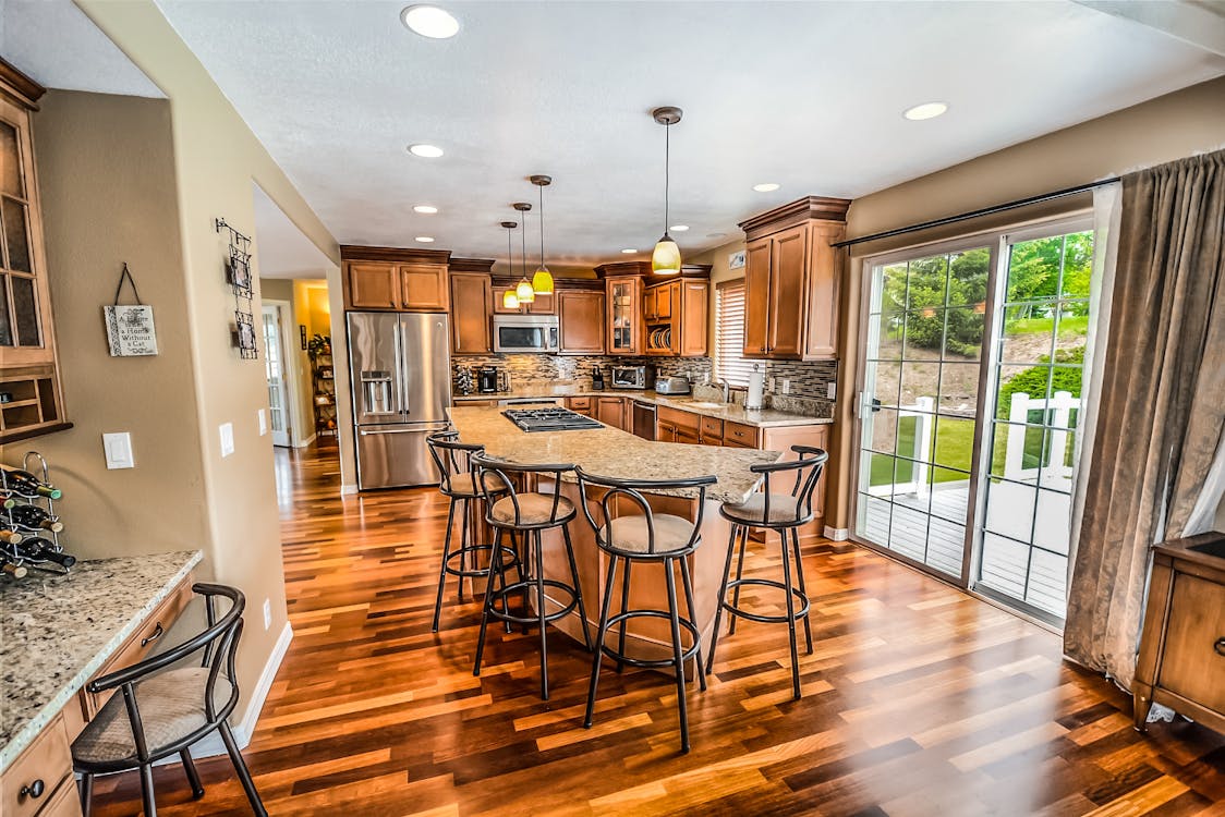 A professional real estate agent in a modern home, thoughtfully inspecting the thermostat, highlighting the importance of HVAC efficiency in a property transaction.