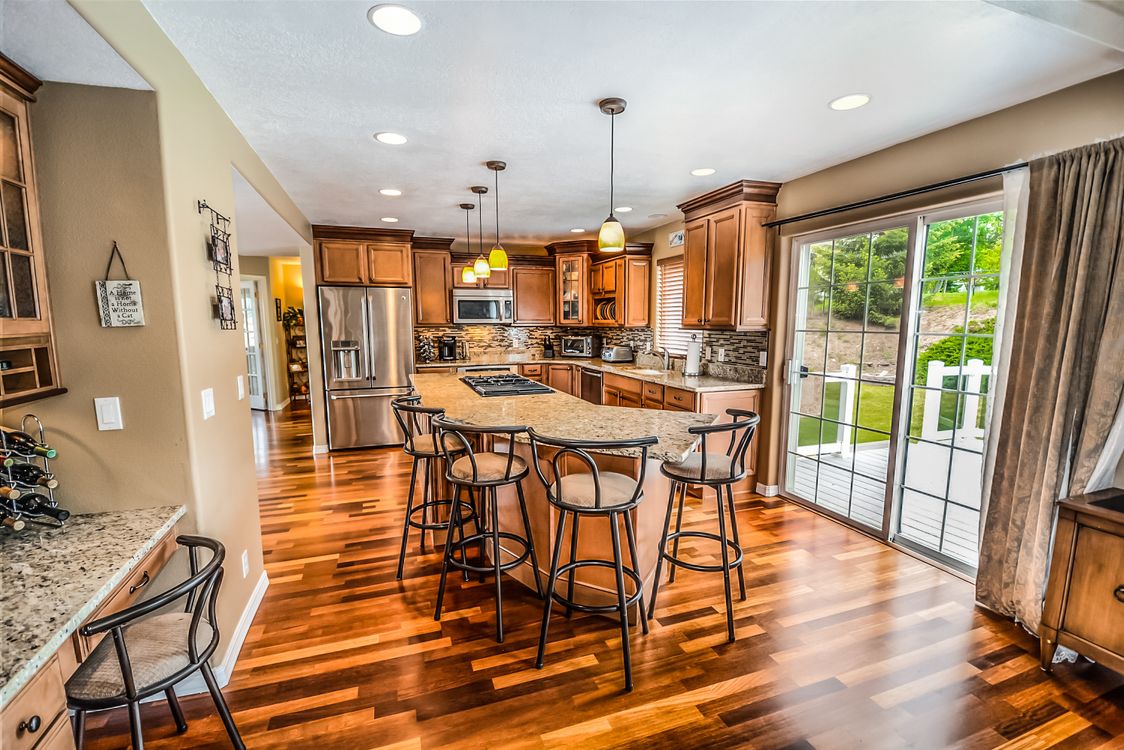 A professional real estate agent hands house keys to a happy couple in front of a modern home, illustrating a successful full-service transaction.