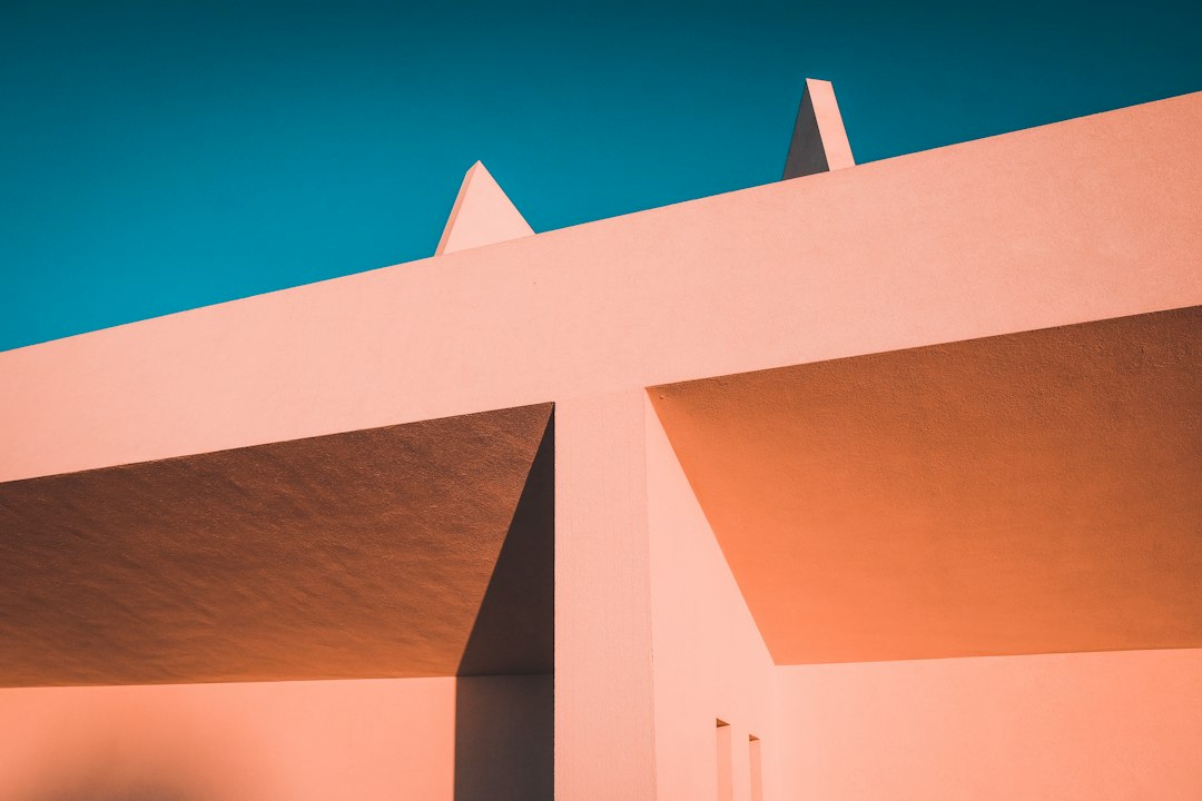 A clean, minimalist photo of two white model houses on a neutral surface with a distinct gap between them, conceptually representing the space between two different values.